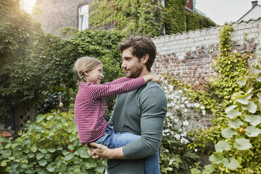 Father carrying daughter in garden of their home - RORF01606