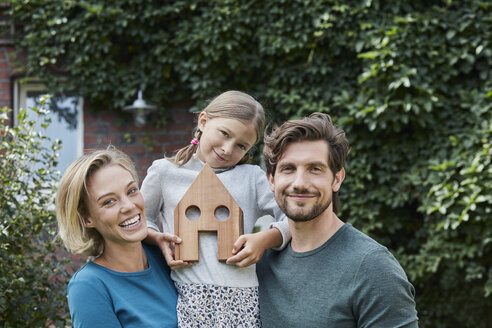 Portrait of happy family in front of their home with house model - RORF01622