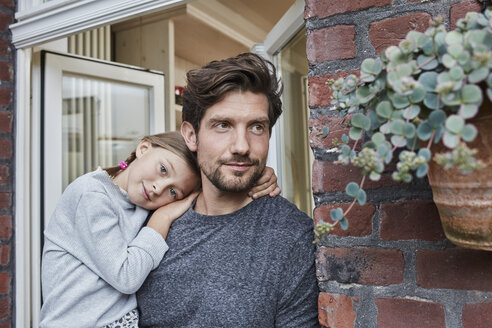 Portrait of father with daughter at house entrance of their home - RORF01636