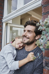 Lächelnder Vater mit Tochter am Hauseingang ihres Wohnhauses - RORF01638