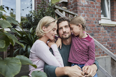 Family sitting on stairs cuddling - RORF01646