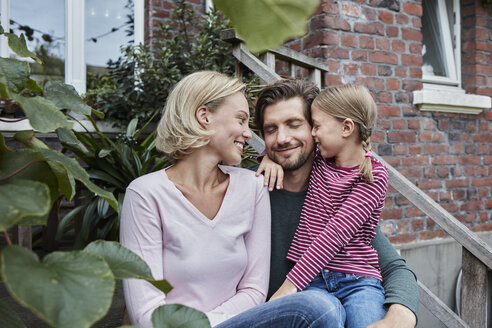 Glückliche Familie auf der Treppe sitzend und kuschelnd - RORF01647