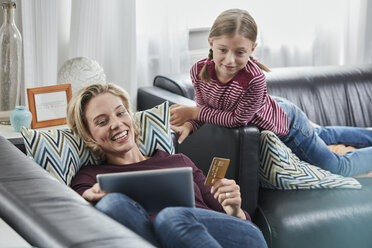 Glückliche Mutter und Tochter beim Online-Shopping auf der Couch zu Hause - RORF01654