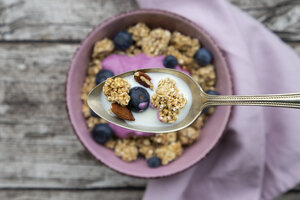 Müsli, Mandeln, Blaubeeren und Milch auf einem Löffel, Nahaufnahme - LVF07666