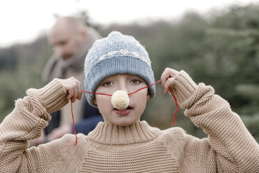 Portrait of a boy putting on woolen nose - KMKF00732