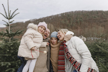 Portrait of happy family with two children on a Christmas tree plantation - KMKF00739