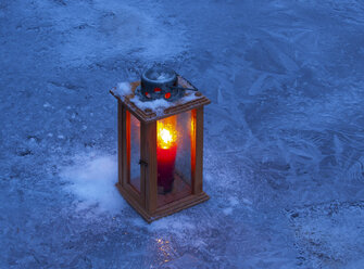 Brennende Laterne auf dem Eis zur blauen Stunde - WWF04877