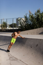 Muskulöser Mann mit nacktem Oberkörper beim Training in einem Skatepark - MAUF02377