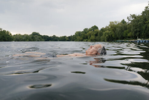 Älterer Mann schwimmt in einem See - GUSF01792