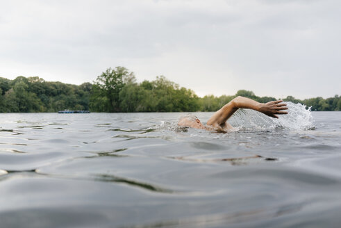 Älterer Mann schwimmt in einem See - GUSF01793