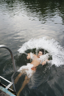 Mann springt vom Steg in einen See - GUSF01794