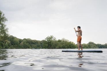 Mann auf SUP-Board auf einem See - GUSF01798