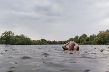 Älterer Mann schwimmt in einem See - GUSF01834