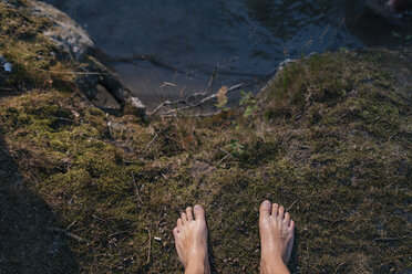 Feet of a man standing at the lakeside - GUSF01850