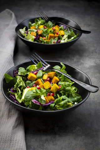 Gemischter Salat mit gebratenem Tofu, Rotkohl, Granatapfelkernen und Kurkuma, lizenzfreies Stockfoto