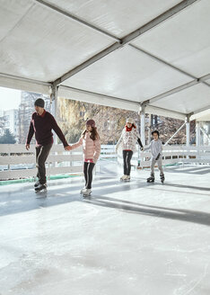 Familie mit zwei Kindern beim Schlittschuhlaufen auf der Eislaufbahn - ZEDF01790