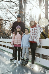 Family leaning on railing at the ice rink - ZEDF01794