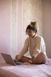 junge Frau auf dem Bett sitzend mit Laptop - ACPF00385