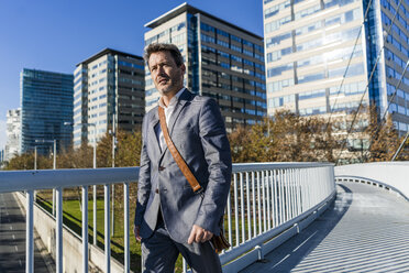 Businessman walking on a bridge - GIOF05563