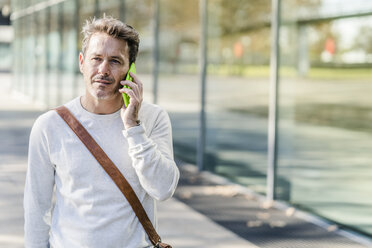 Mature man commuiting in the city, talking on the phone - GIOF05579