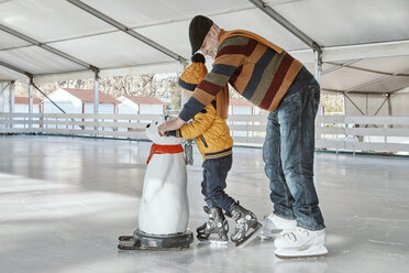 Großvater und Enkel auf der Eisbahn, Schlittschuhlaufen, mit Eisbärenfigur als Requisite - ZEDF01803