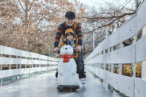 Großvater und Enkel auf der Eisbahn, Schlittschuhlaufen, mit Eisbärenfigur als Requisite - ZEDF01805