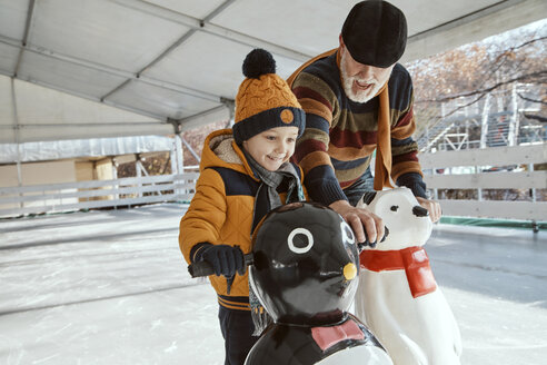 Großvater und Enkel auf der Eisbahn, Schlittschuhlaufen, mit Eisbärenfigur als Requisite - ZEDF01811