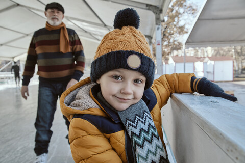 Großvater und Enkel auf der Eisbahn, Schlittschuhlaufen, lizenzfreies Stockfoto