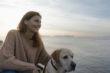 Germany, Hamburg, smiling woman with dog at the Elbe shore - JOSF02874