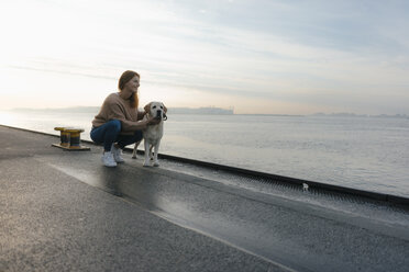 Deutschland, Hamburg, Frau mit Hund auf Pier am Elbufer - JOSF02875