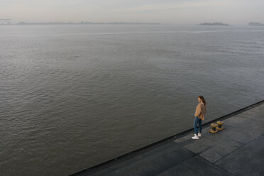 Deutschland, Hamburg, Blick von oben auf eine Frau auf dem Pier am Elbufer - JOSF02879