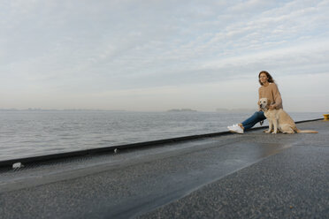 Deutschland, Hamburg, Frau mit Hund auf Pier am Elbufer - JOSF02880