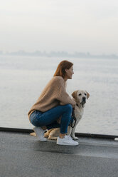 Deutschland, Hamburg, Frau mit Hund auf Pier am Elbufer - JOSF02904