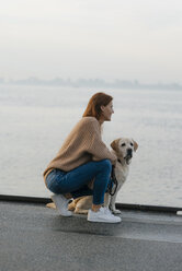 Germany, Hamburg, woman with dog on pier at the Elbe shore - JOSF02904