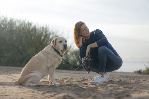 Deutschland, Hamburg, Frau mit Hund am Strand am Elbufer - JOSF02908