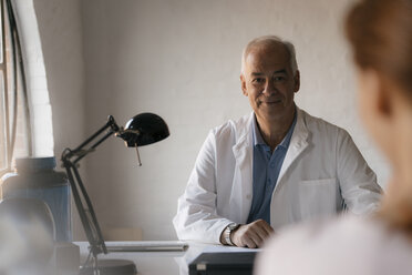 Senior doctor looking at female patient in medical practice - JOSF02928