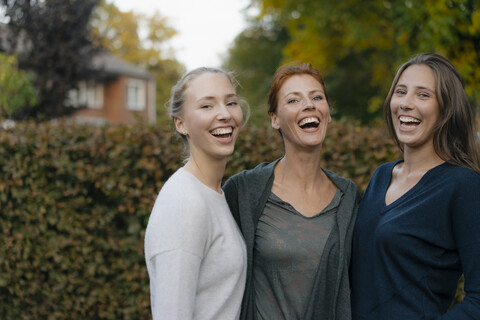 Porträt einer glücklichen Mutter mit zwei Teenager-Mädchen im Garten, lizenzfreies Stockfoto