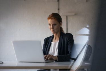 Geschäftsfrau mit Laptop am Schreibtisch im Büro - JOSF02998
