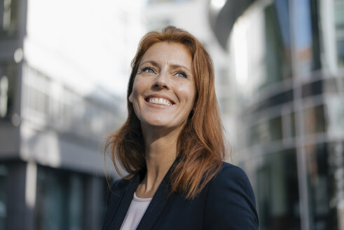 Portrait of smiling businesswoman outdoors in the city - JOSF03047