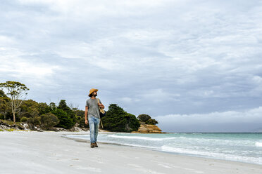 Australia, Tasmania, Maria Island, man strolling on the beach - KIJF02174