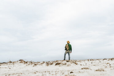 Australien, Tasmanien, Maria Island, Rückenansicht eines Mannes mit Rucksack am Strand mit Blick in die Ferne - KIJF02181