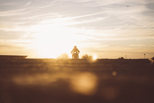 Silhouette eines Mannes auf einem Custum-Motorrad bei Sonnenuntergang - OCMF00222