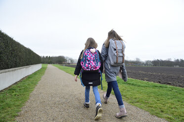 Two sisters with backpacks walking side by side - ECPF00272