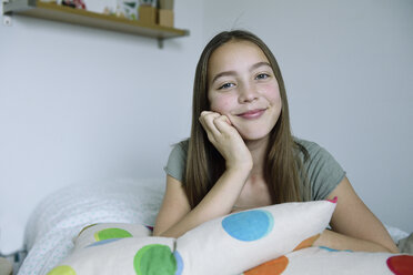 Porträt eines lächelnden Mädchens auf dem Bett liegend - ECPF00274