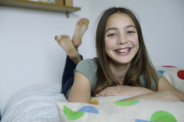 Porträt eines lachenden Mädchens auf dem Bett liegend - ECPF00277