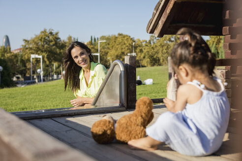 Smiling mother with daughter on a playground - MAUF02405