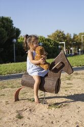 Kleines Mädchen auf Schaukelpferd auf einem Spielplatz - MAUF02408