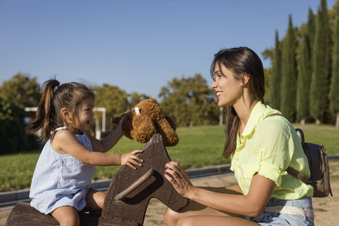 Happy mother with daughter on a playground - MAUF02409