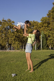 Happy mother playing with daughter in a park - MAUF02417