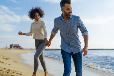 Spain, Barcelona, happy couple having fun on the beach - BOYF01276